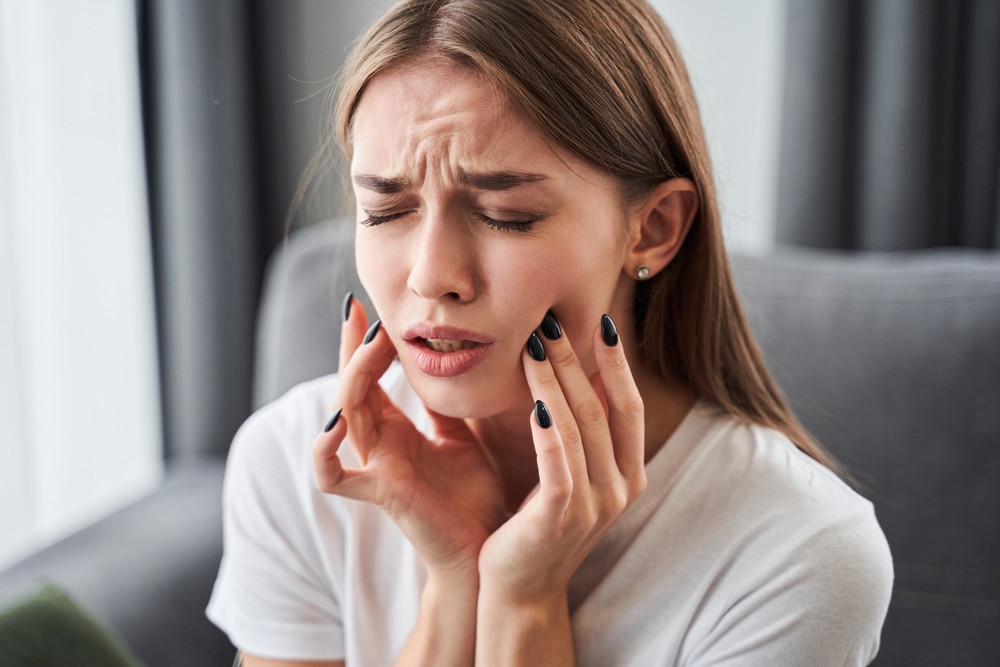 woman with jaw pain and toothache before seeing an emergency dentist and getting TMJ treatment in Ocala, FL