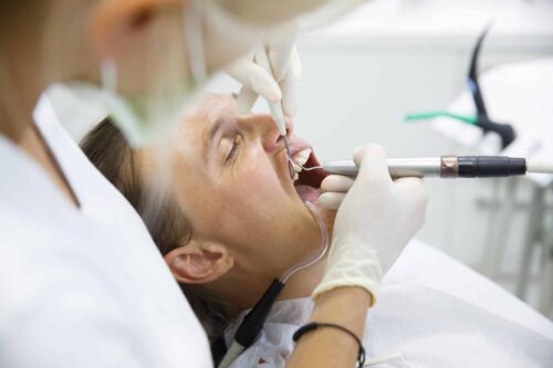 dentist scraping the gum pockets of a patient to fight against gum disease