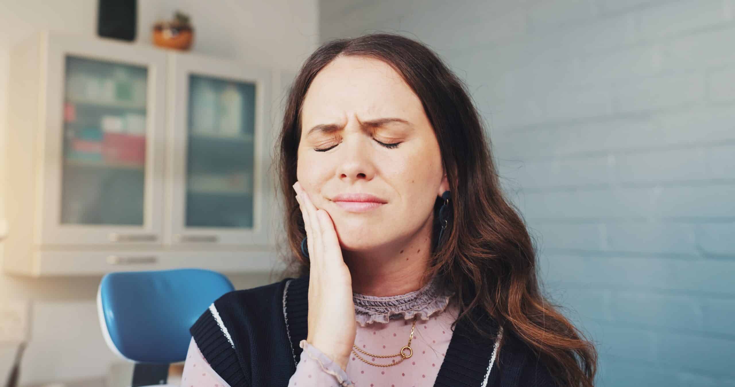 woman holding her jaw with serious tooth pain, need for root canal